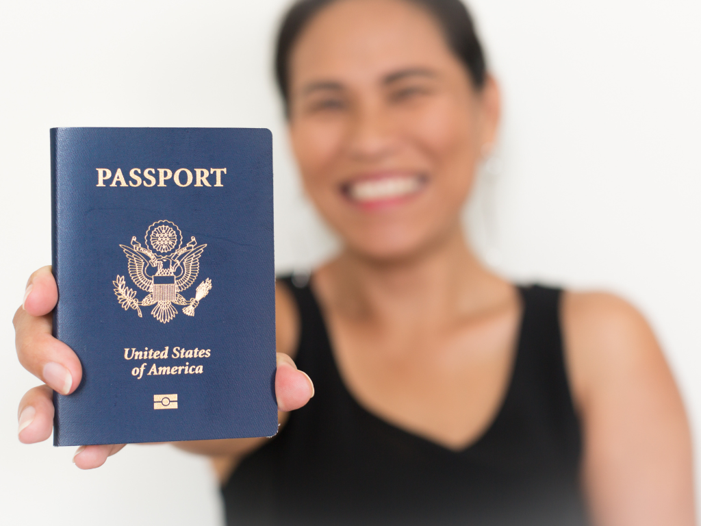 Woman smiling while holding a U.S. passport