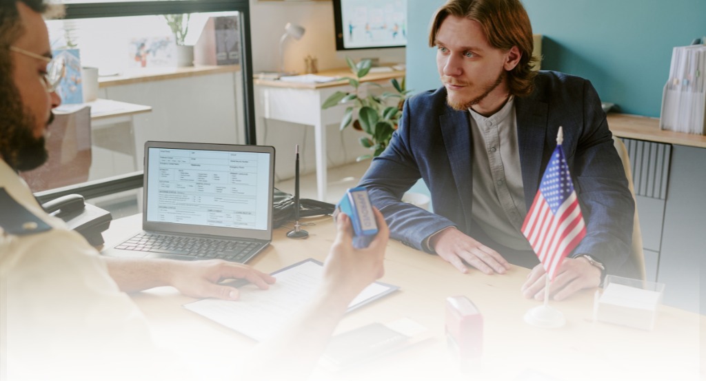 Hands holding visa paperwork and an American flag