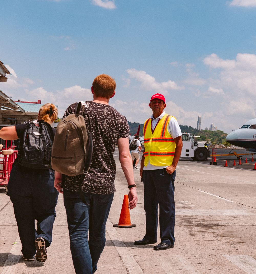 Travelers walking across an airport apron to their flight